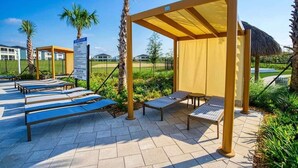 Un espace extérieur abrité, doté de fauteuils confortables et d’une structure en forme de pergola.