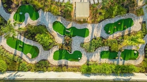 Vue aérienne d’un parcours de golf avec de nombreuses zones verdoyantes et des allées.