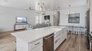 A modern kitchen with a large island, white cabinetry, and pendant lighting. - Modern Family 7BR w Private Pool and Patio (Miramar Beach)