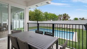 A covered patio with a pool, outdoor furniture, and a view of the backyard. - Modern Family 7BR w Private Pool and Patio (Miramar Beach)