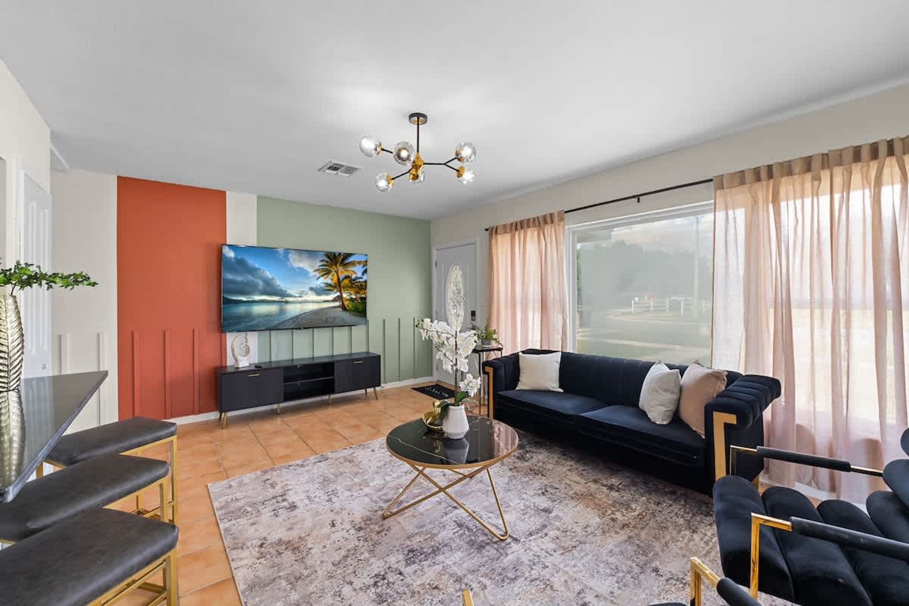 A modern living room with a TV, sofa, and dining area.