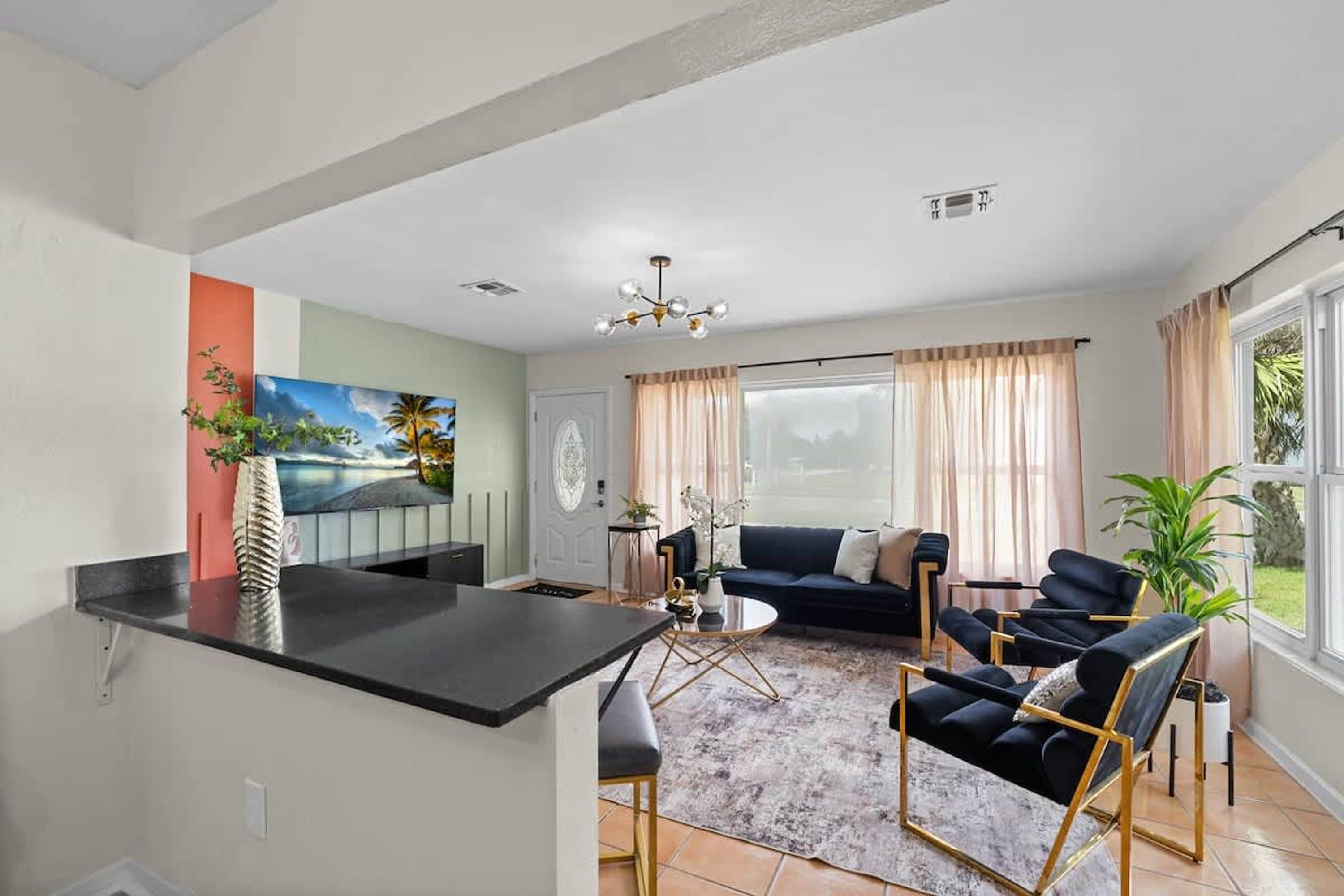 A living room with a sofa, chairs, a coffee table, and a TV.