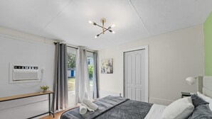 Un dormitorio moderno con una cama, una mesita de noche y una lámpara en el techo.