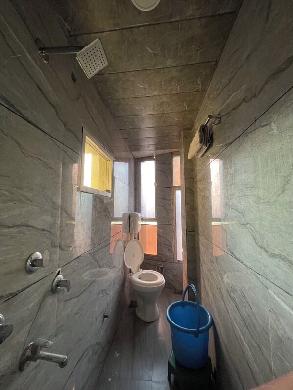 Un baño con inodoro, lavamanos y zona de ducha.