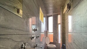 A bathroom with a large sink, toilet, and a blue bucket. - LOTO HOTEL MAHAKAL Ujjain Tower Chowk (Ujjain)