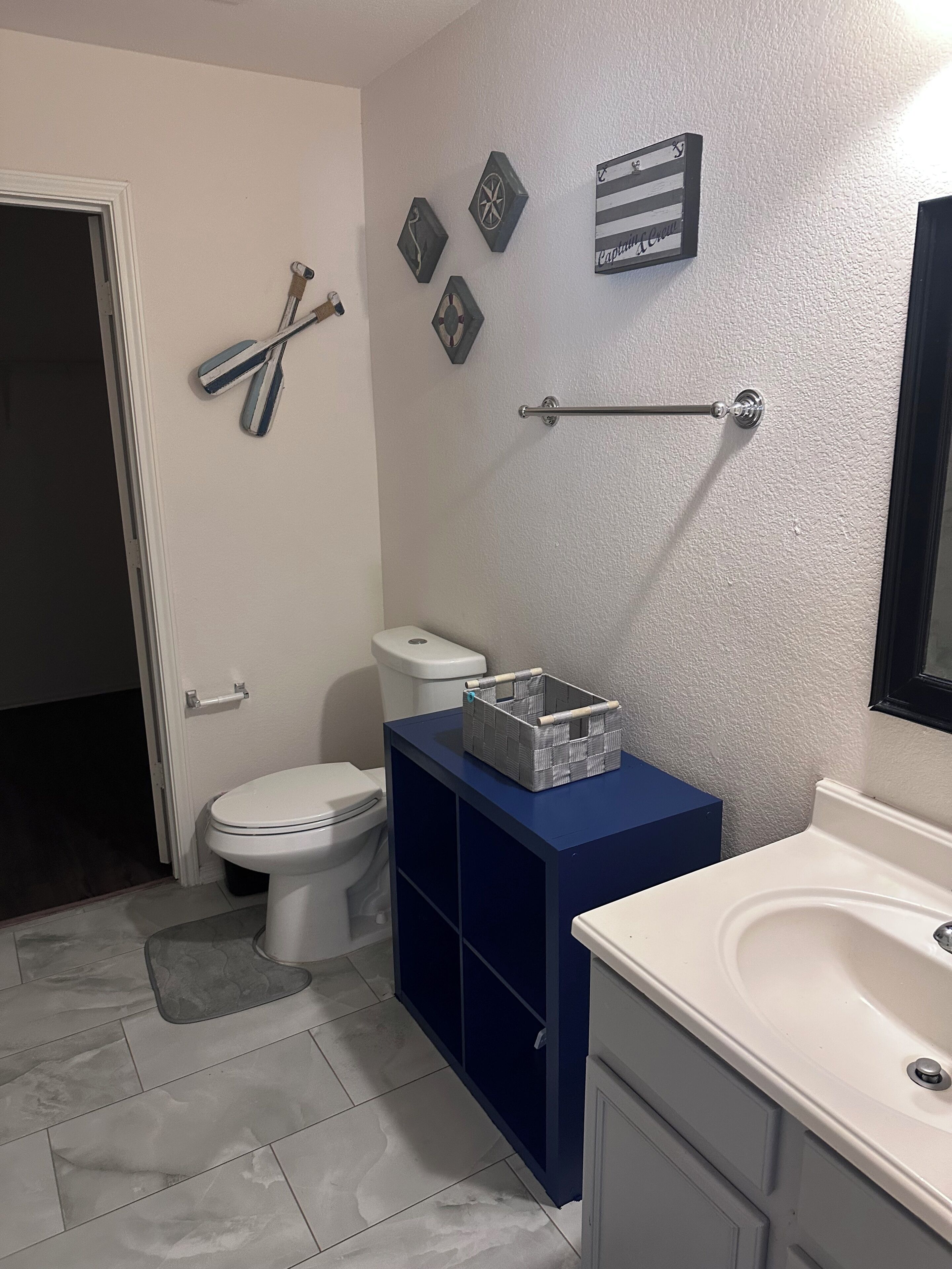 Ein Badezimmer mit Toilette, Bidet, Waschbecken und einem blauen Schrank.