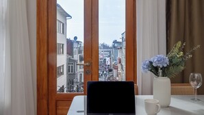 A laptop on a table with a view of a cityscape through a window. - Acme Studio 2 (İstanbul)