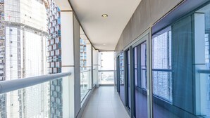 A corridor with large windows, a tiled floor, and a view of high-rise buildings. - Superhost 1BR DAMAC Towers Paramount (Dubai)