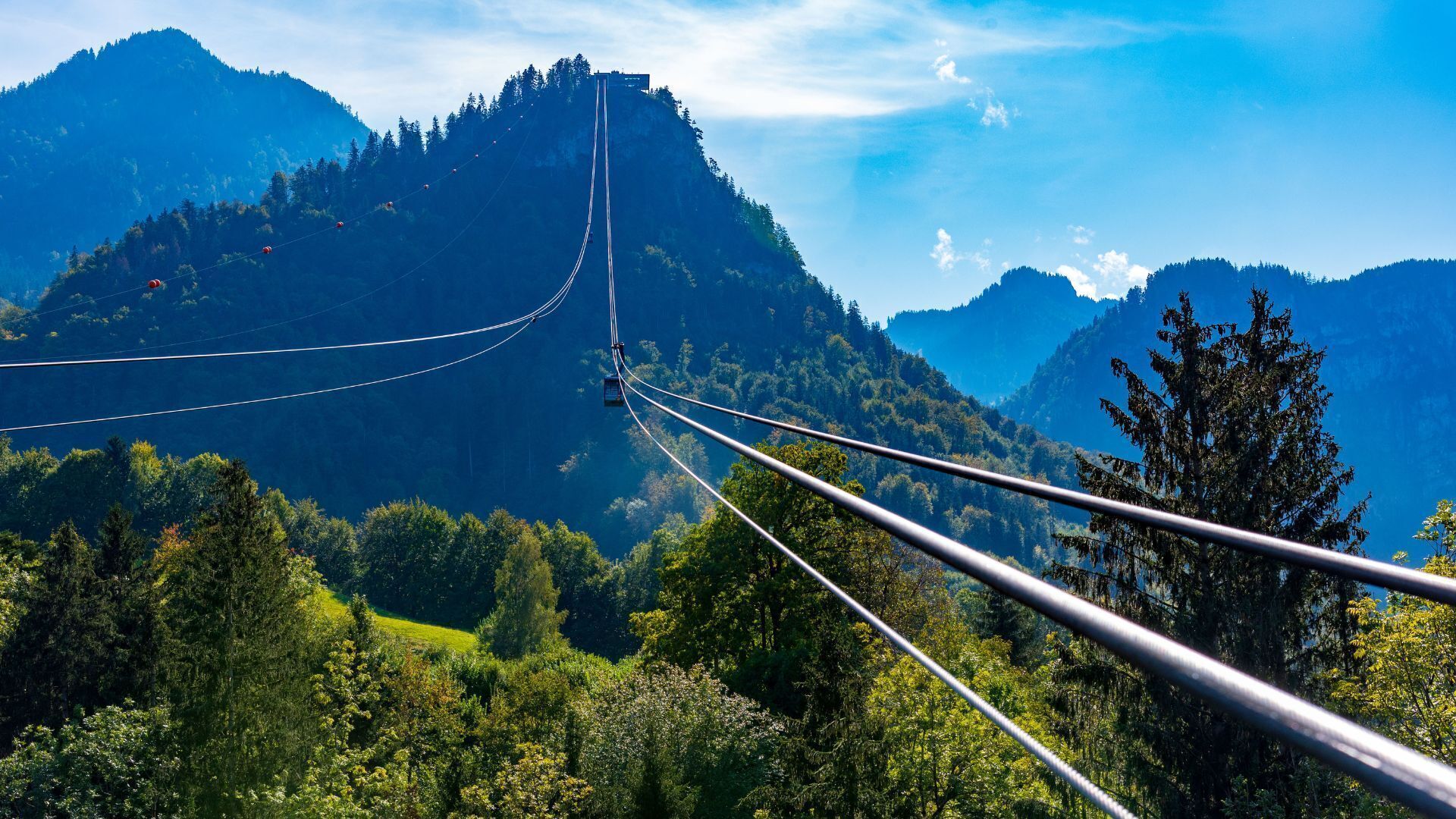 A cable car system with a mountainous backdrop.
