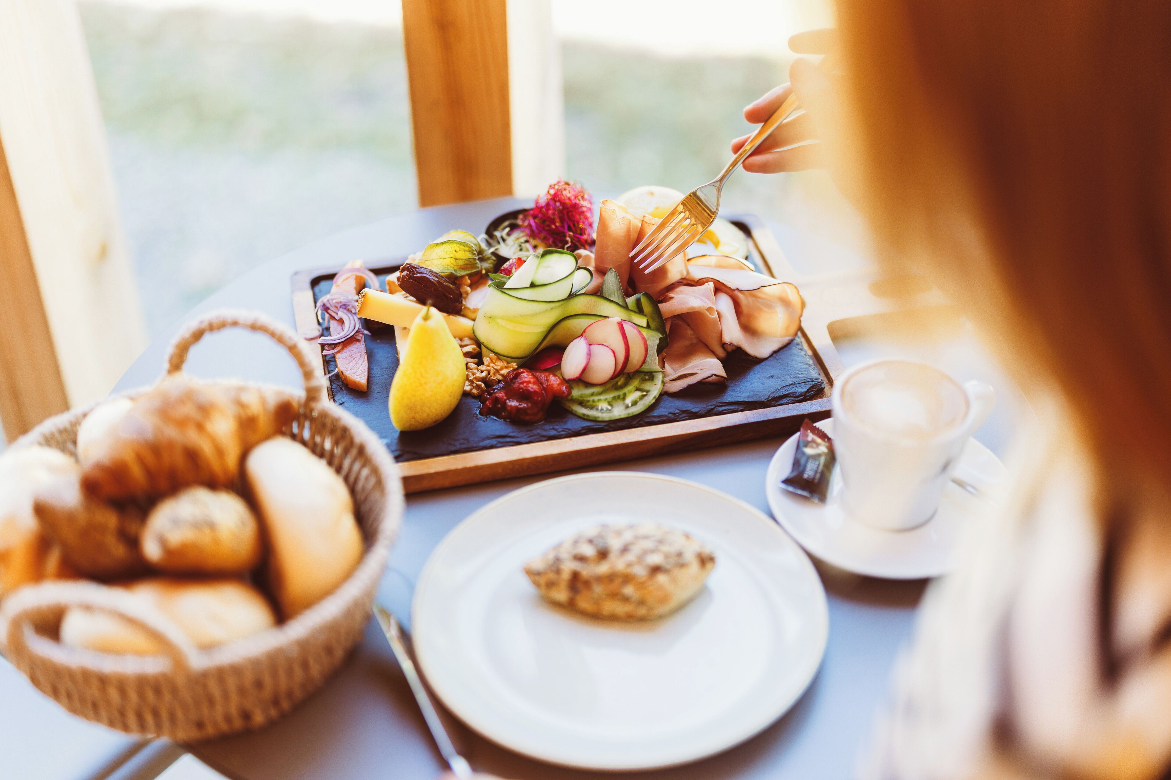 A breakfast buffet with various pastries, fruits, and a coffee cup.