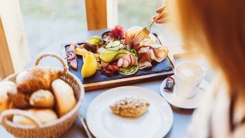 A breakfast buffet with various pastries, fruits, and a coffee cup.