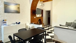 A dining area with a black and white checkered floor, a wooden ceiling, and a painting on the wall. - Il Cortiletto di Ortigia - Two-room apartment (Siracusa)