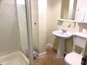 Een douche, handdoeken, zeep, shampoo