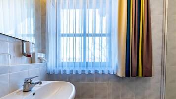 Habitación doble, vista al jardín | Baño | Regadera, secadora de cabello, toallas, jabón