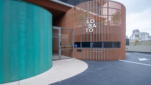 En moderne bygning med en buet facade og et skilt, der viser "JARDIM LOBA TO".
