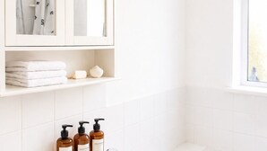 A bathroom with a white sink, three shampoo bottles, a mirror cabinet, and a bathtub. - Stunning 3-Bed House in the Heart of Newport, Sleeps 7 (Newport)