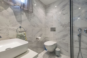 A bathroom with a marble floor, a white sink, a toilet, and a shower area. - Db11 Adjacent to Aphrodite Hills Communal Pool Retreat (Kouklia)