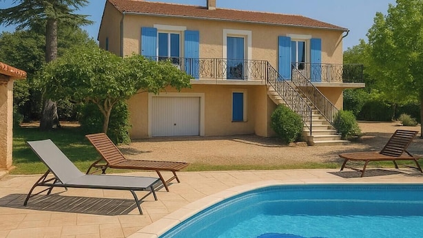 Una casa de dues plantes amb piscina, garatge cobert i escala cap a un balcó.