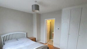 Ein Schlafzimmer mit einem Bett, einem Kleiderschrank und einer Tür zu einem anderen Raum.