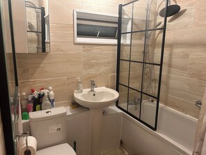 A bathroom with a sink, toilet, and shower area.