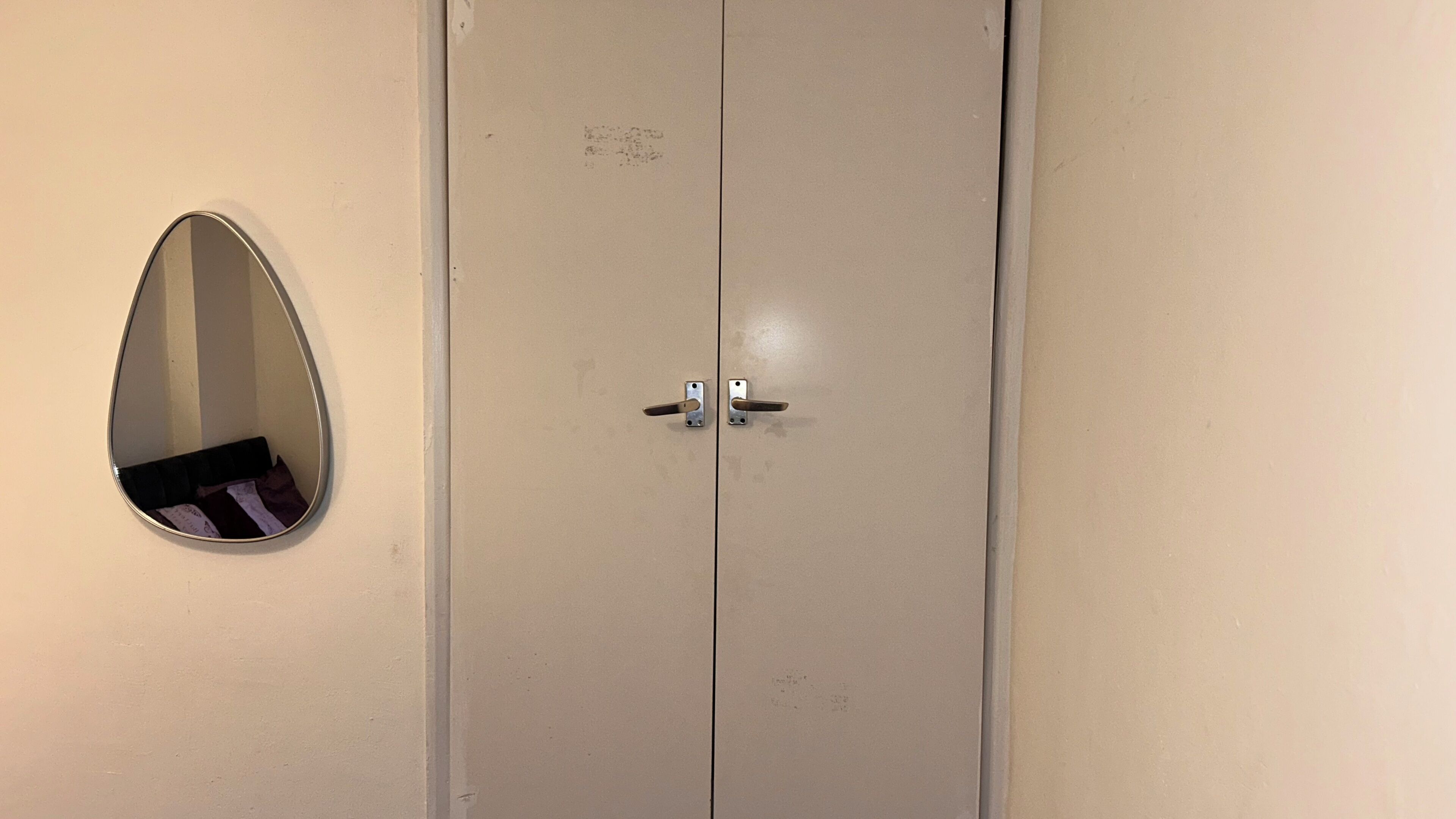 A double door with a small mirror on the left.