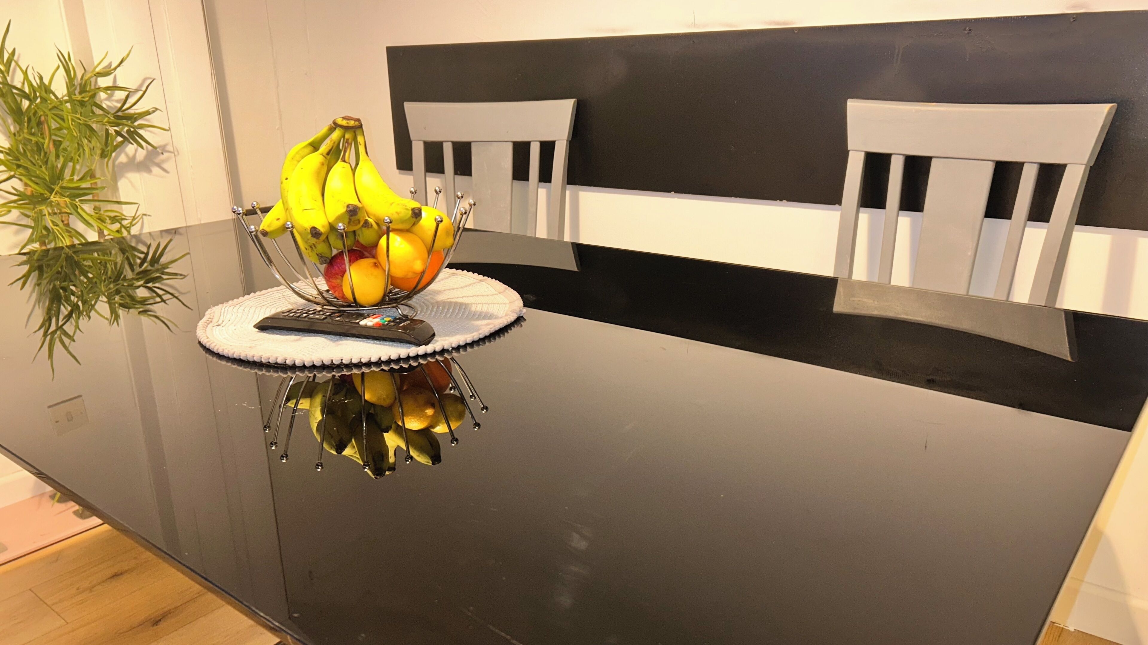 Una encimera de cocina con un frutero que contiene plátanos, manzanas y naranjas.