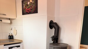 Eine kompakte Küche mit Einbauherd, Geschirrspüler und einem Wandbild.