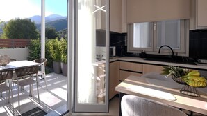 Una cocina moderna con un ventanal grande, un comedor con mesa y sillas, y vistas al exterior.