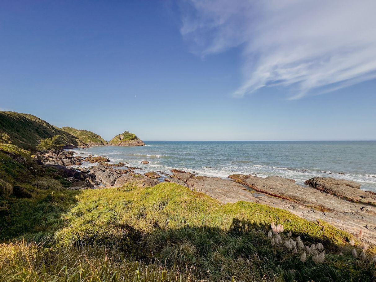 A coastal landscape with rocky terrain and grassy areas.