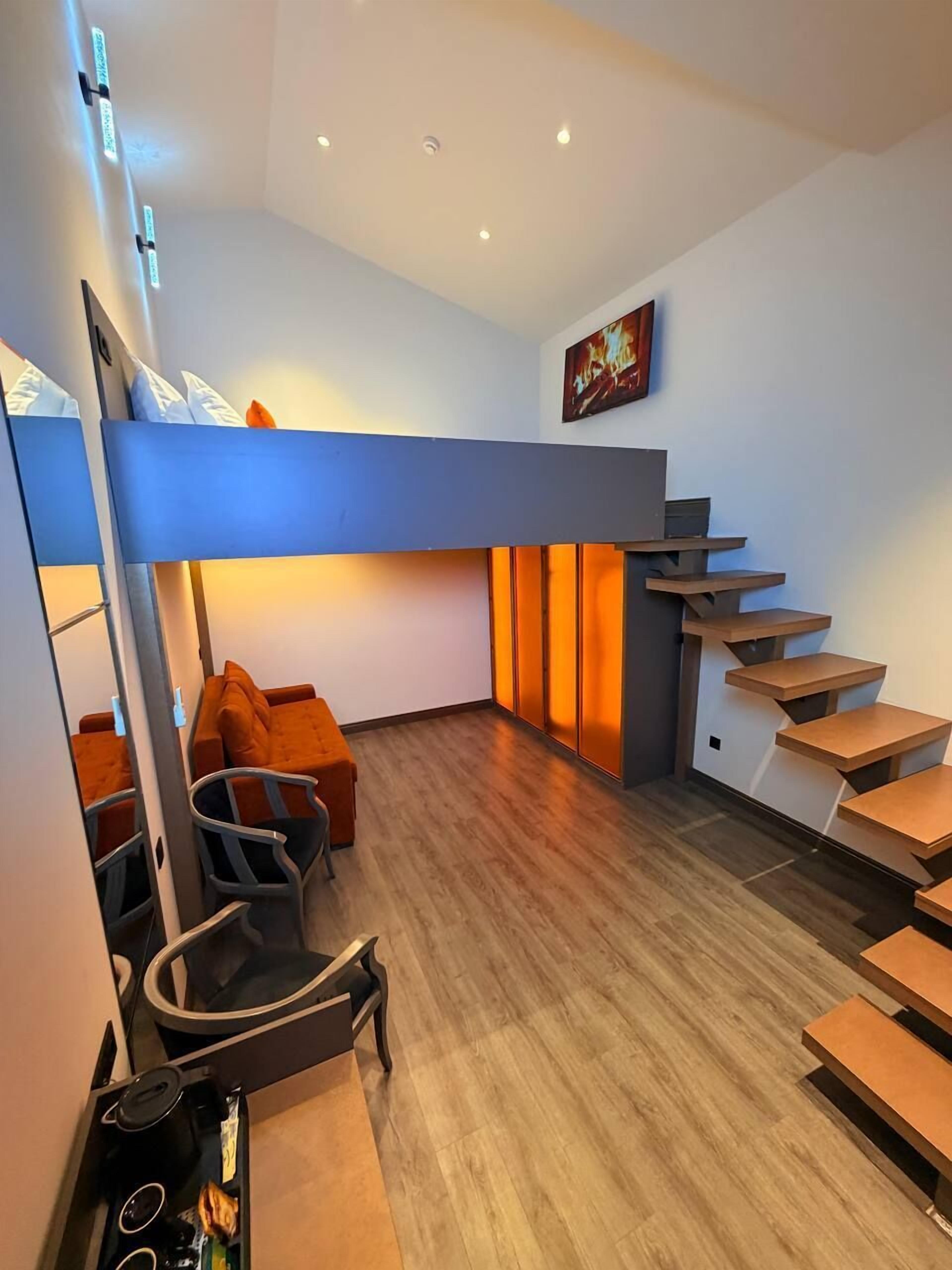 Ein modernes Interieur mit einem Stockbett, Holzboden, einer Treppe und einem Bild an der Wand.