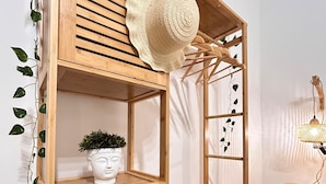 A wooden bunk bed with a decorative hat on the top shelf, a small potted plant, and a hanging lamp. - Di Fiore Guesthouse (Naples)