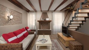 A living room with a sofa, fireplace, TV, and staircase. - Dimore Holiday Home Silva (Rovinj)