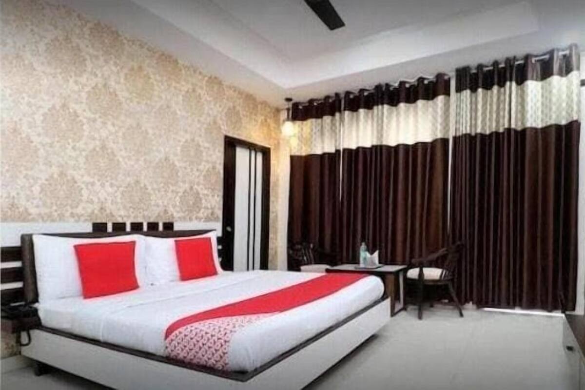 Una habitación de hotel con una cama grande, un escritorio, una silla y un televisor.