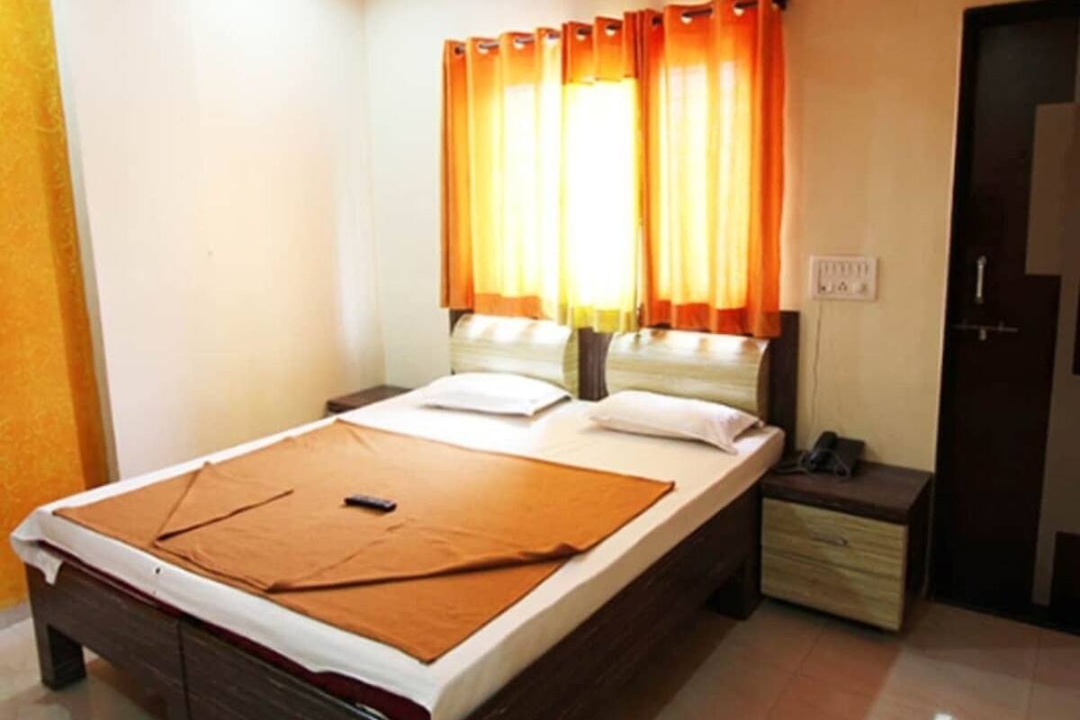 Un dormitorio con cama, mesita de noche, ventilador de techo y puerta.