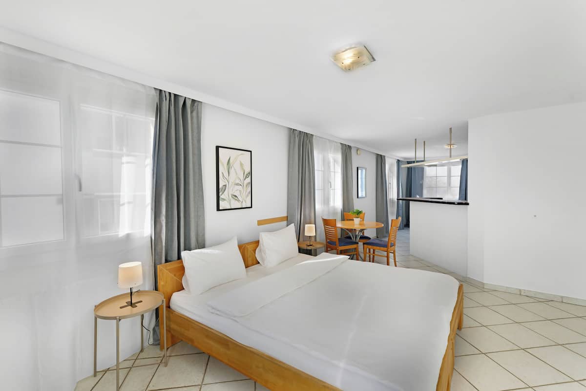 Ein Hotelzimmer mit einem großen Bett, einem Schreibtisch und einem Stuhl.