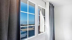 A room with a large window offering a view of a parking lot and a dock.