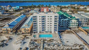 A coastal hotel with multiple buildings, a swimming pool, and beachfront access. - Shoreline Towers (Gulf Shores)