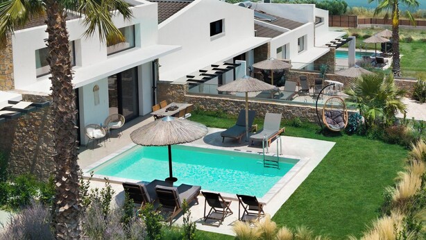 Una casa moderna con piscina, mobiliario exterior y vistas al mar.