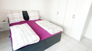 A bedroom with a bed, wardrobe, and a nightstand. - Schwalbennest Vacation Rental: 5 Minutes to the Baggersee (Kronau)
