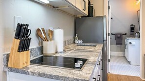 A modern kitchen with a built-in stove, knife block, and wooden utensils. - The Claret Cup Suite at The Hesch - Premier Location- Railyard Arts District (Santa Fe)