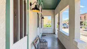 A covered corridor with a bench, windows, and a view of the street. - The Claret Cup Suite at The Hesch - Premier Location- Railyard Arts District (Santa Fe)