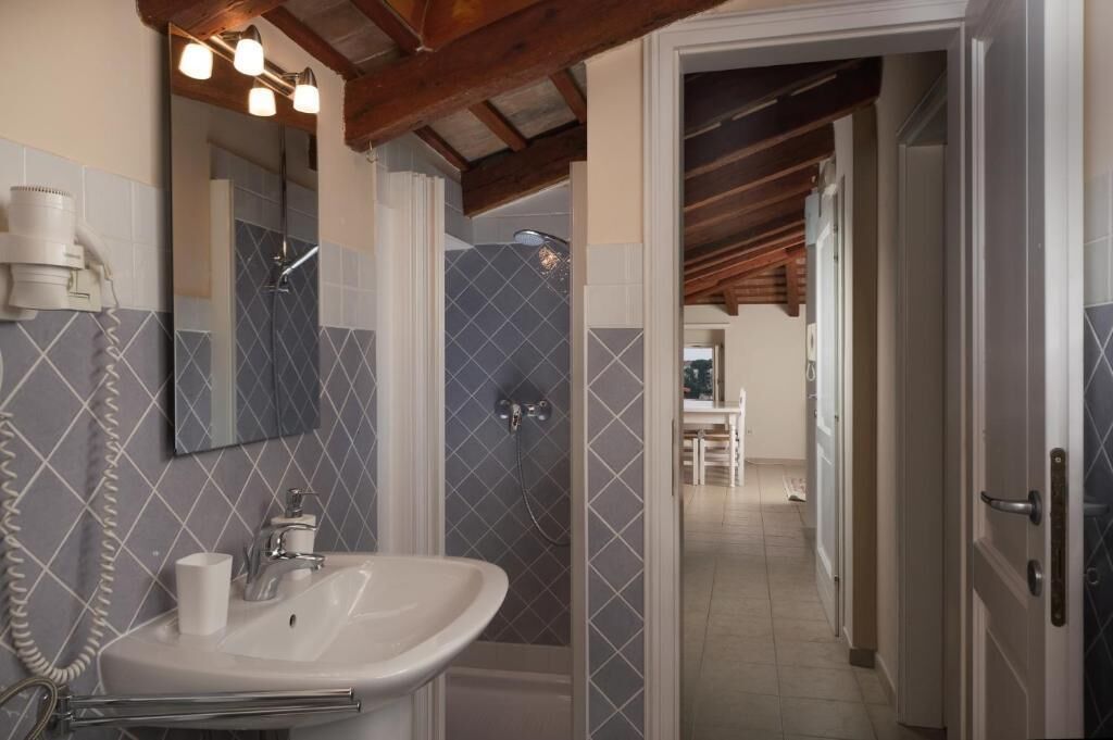 Baño con lavamanos, espejo y ducha.