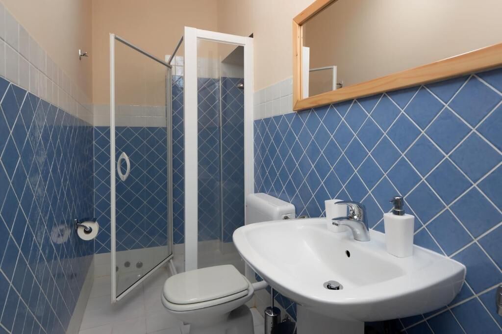 A bathroom with a shower, toilet, and sink.