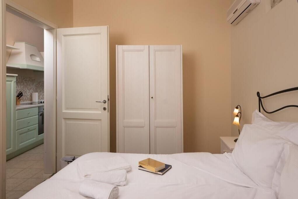 Un dormitorio con una cama, una mesita de noche con lámpara y un armario.