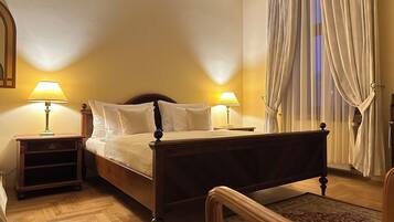 Un letto rifatto con due abat-jour, un comodino in legno, una testiera in legno e un tappeto decorativo su un pavimento in legno.