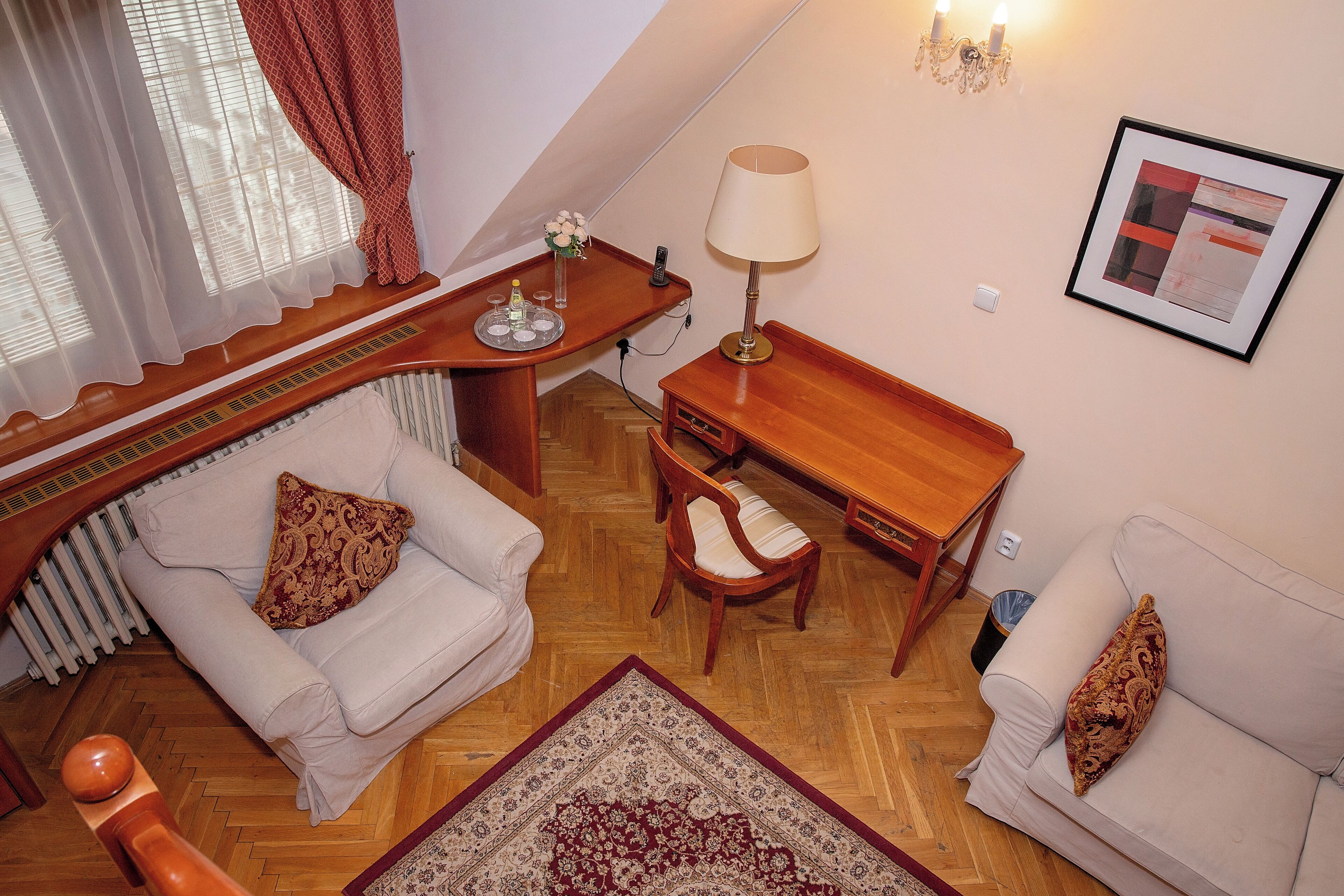 A cozy living room with a sofa, a wooden coffee table, a lamp, and a framed picture on the wall.