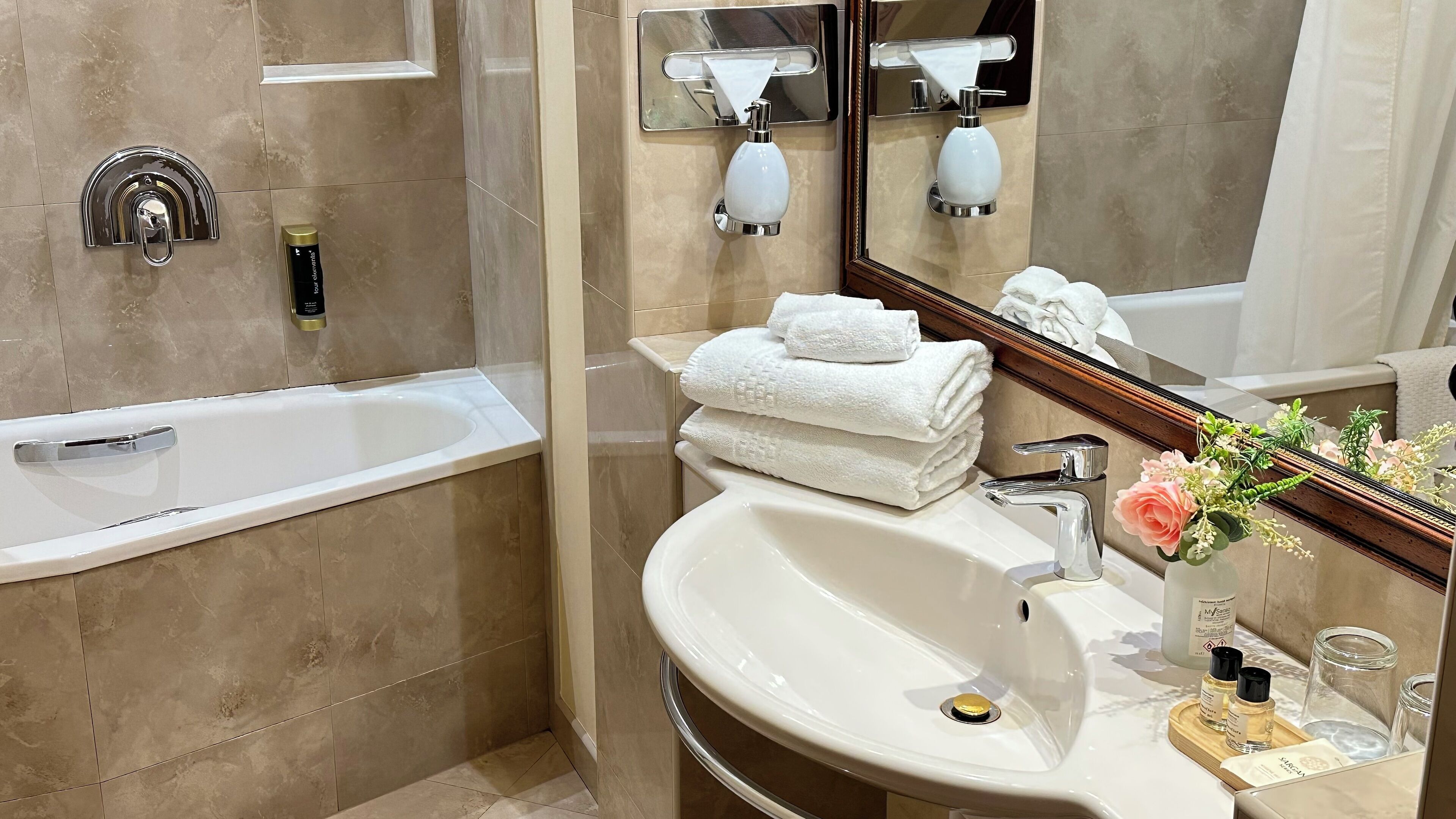 Un baño moderno con bañera, lavamanos y espejo.
