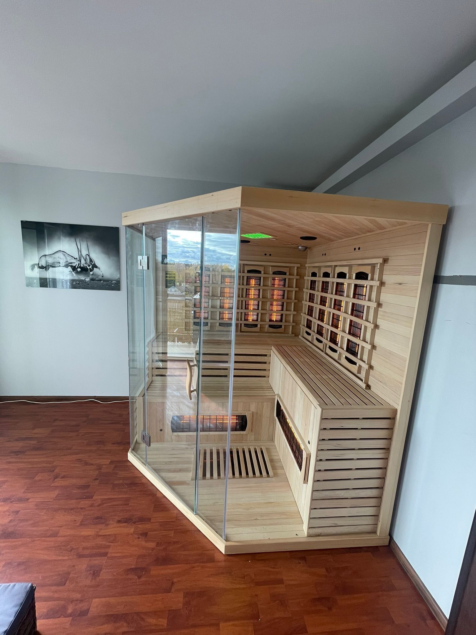 Une pièce d’angle avec une cloison en verre, des étagères en bois et une vue sur l’extérieur.