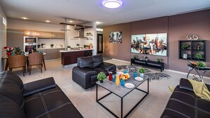 Een moderne woonkamer met een bank, salontafel en kunstwerk aan de muur.