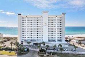 Ein Hochhaus-Hotel mit einer zentralen Atriumlichtkuppel, mehreren Balkonen und Blick auf den Strand.